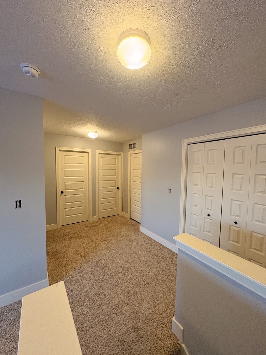 Basement hallway with white painted doors and closets