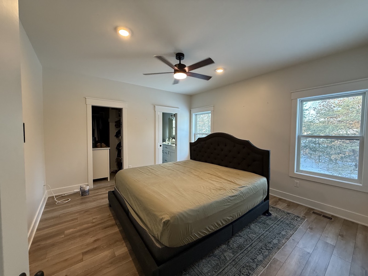 Bedroom with light painted walls and a dark upholstered headboard