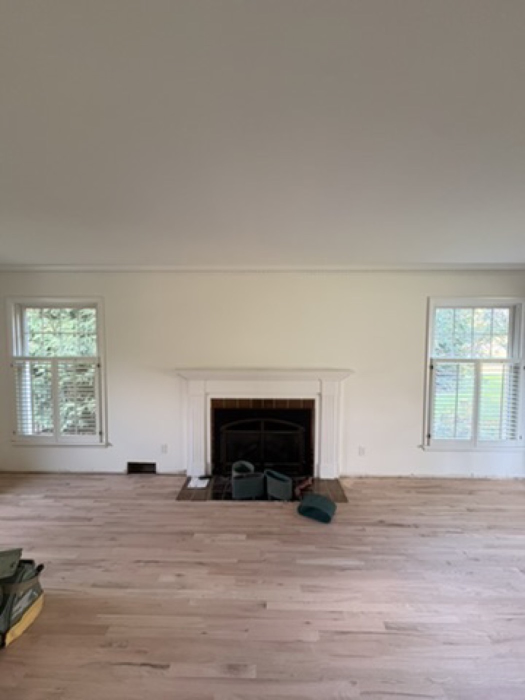 Living room with a painted fireplace mantel during floor refinishing
