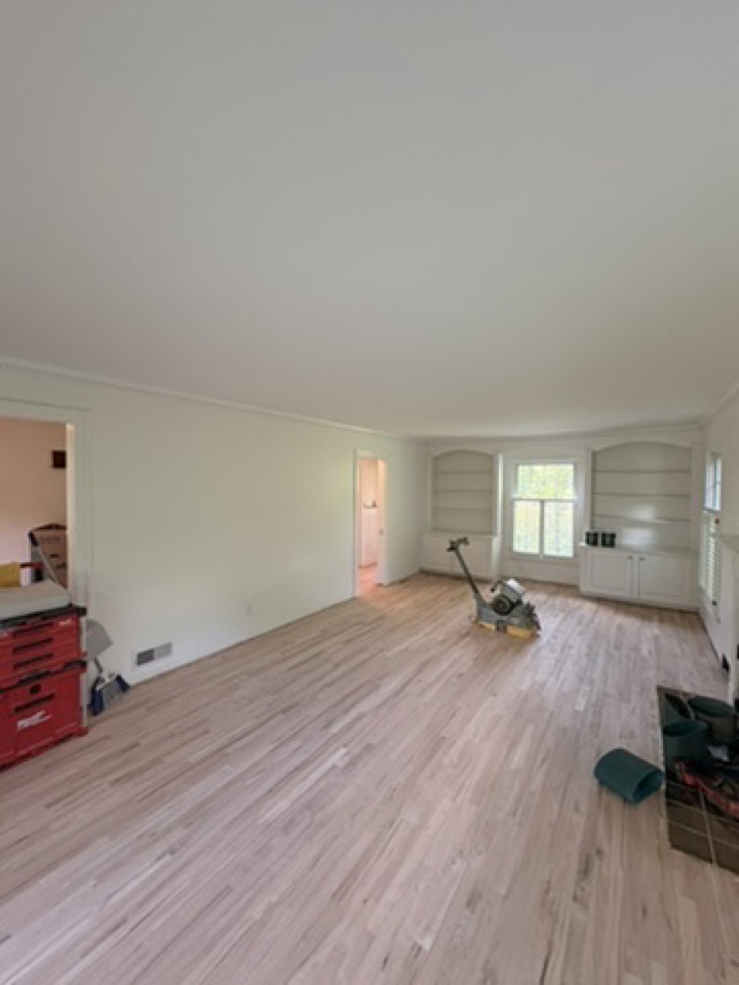 Living room with painted trim and crown molding during floor refinishing