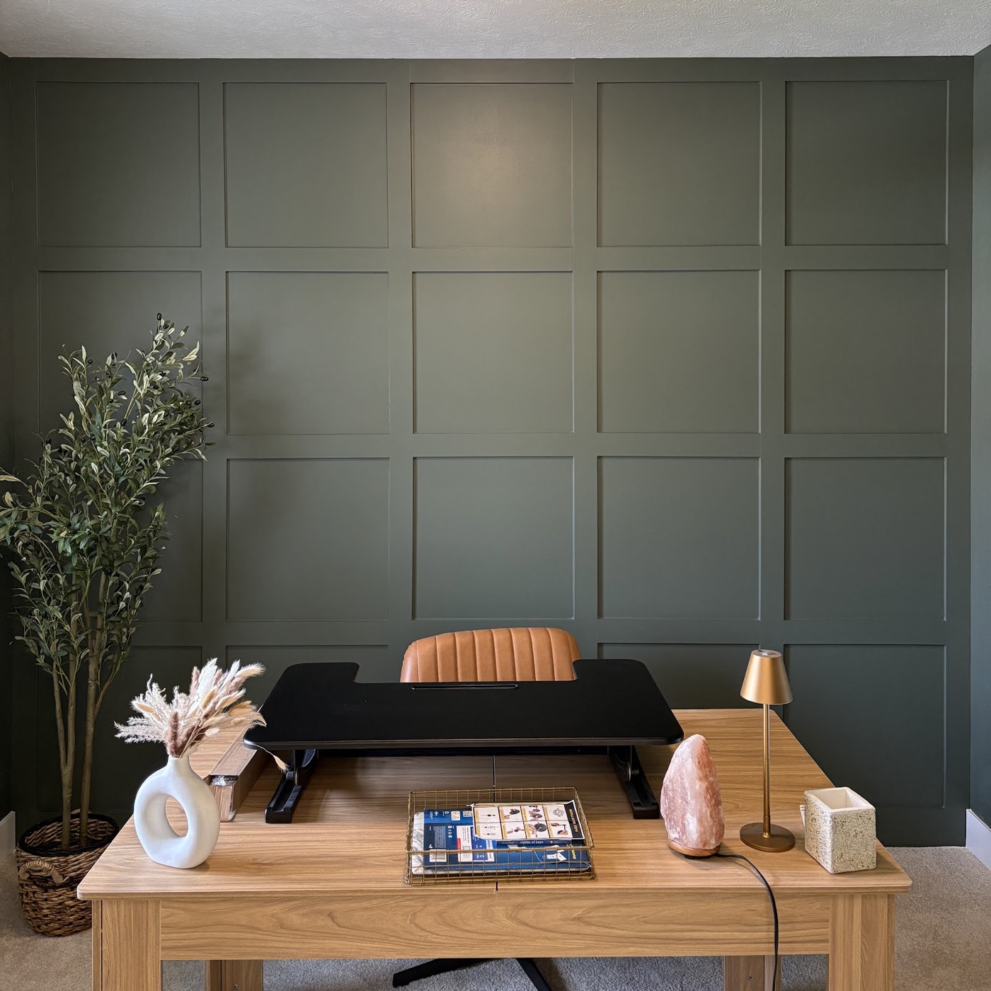 Dark olive green board-and-batten accent wall in a home office with a desk