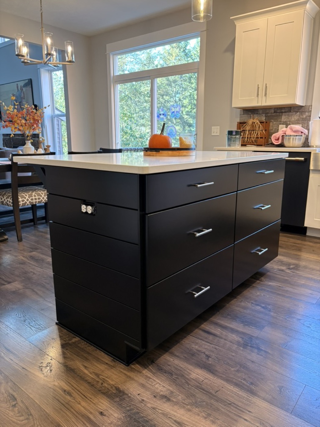 Kitchen with a painted navy blue island, white upper cabinets and pendant lighting