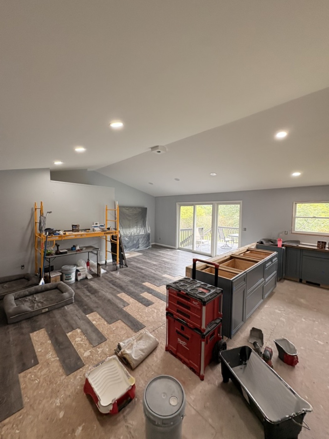 Room mid-renovation with painting supplies, drop cloths and tools laid out before work starts