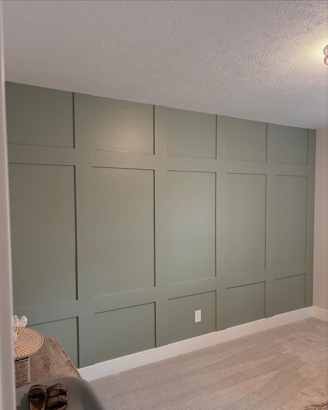 Sage green board-and-batten accent wall in a finished room