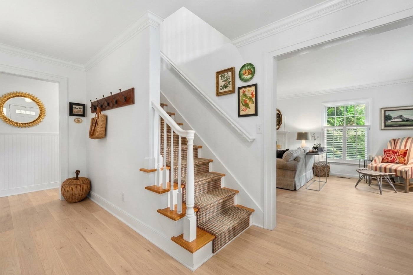 Staircase and entryway with painted white walls, trim and crown molding
