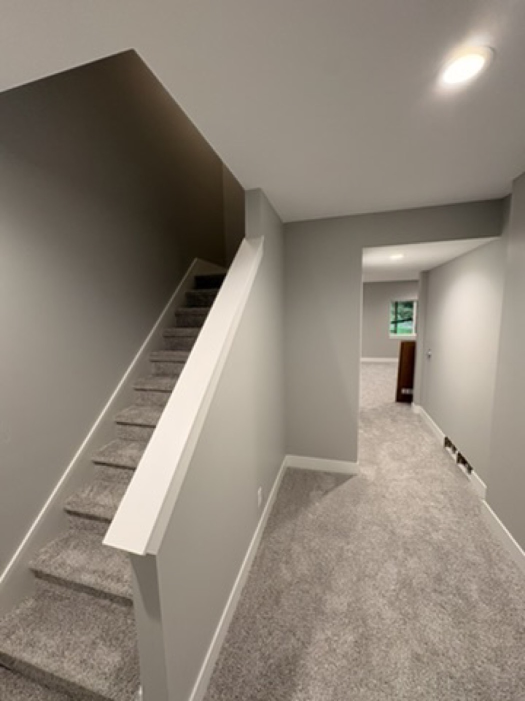 Stairway with dark painted accent trim and grey walls