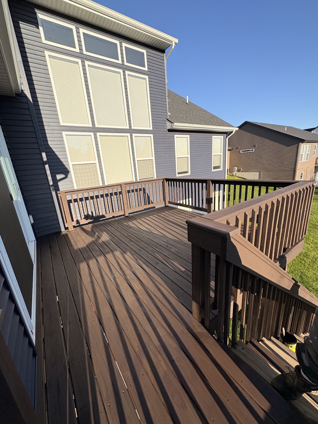 Two-tier stained wood deck overlooking a covered pool